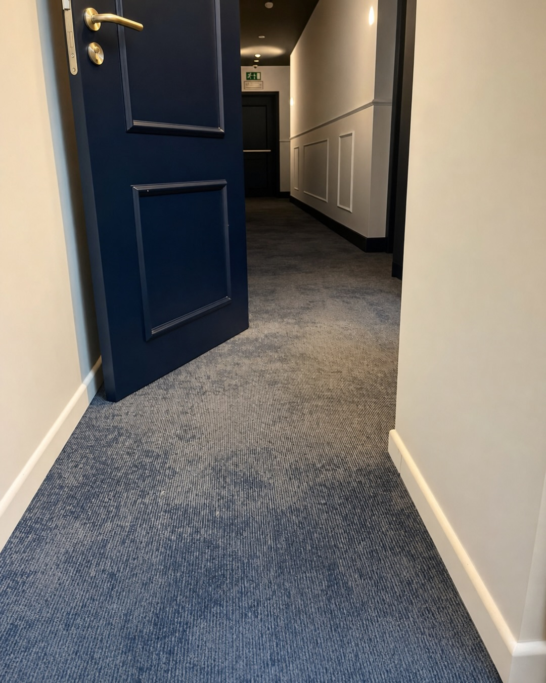 Detail van het tapijt bij een donkerblauwe deur in Hotel Marcel