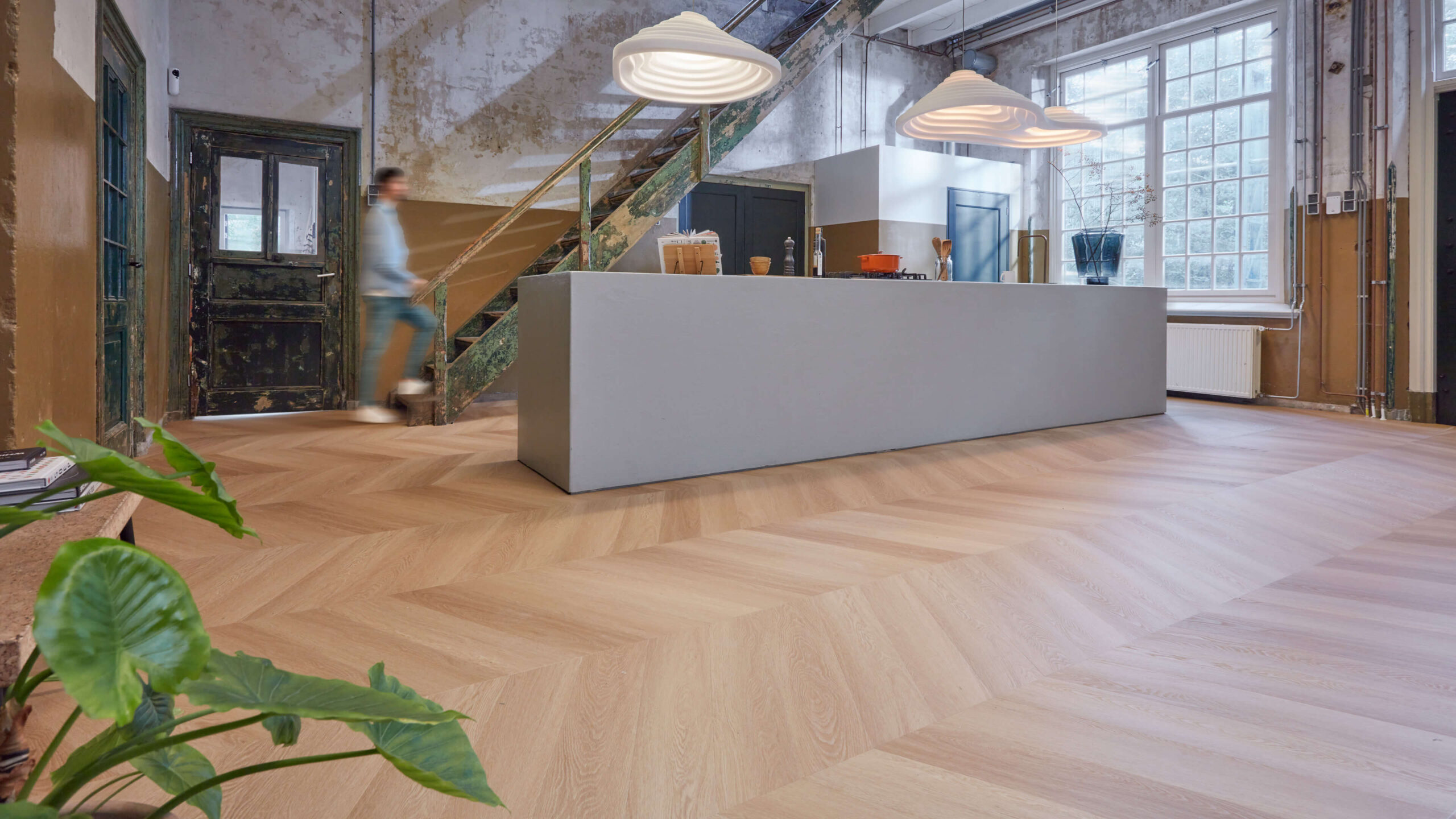 Lichte PVC-vloer met houtlook in een industrieel interieur met kookeiland
